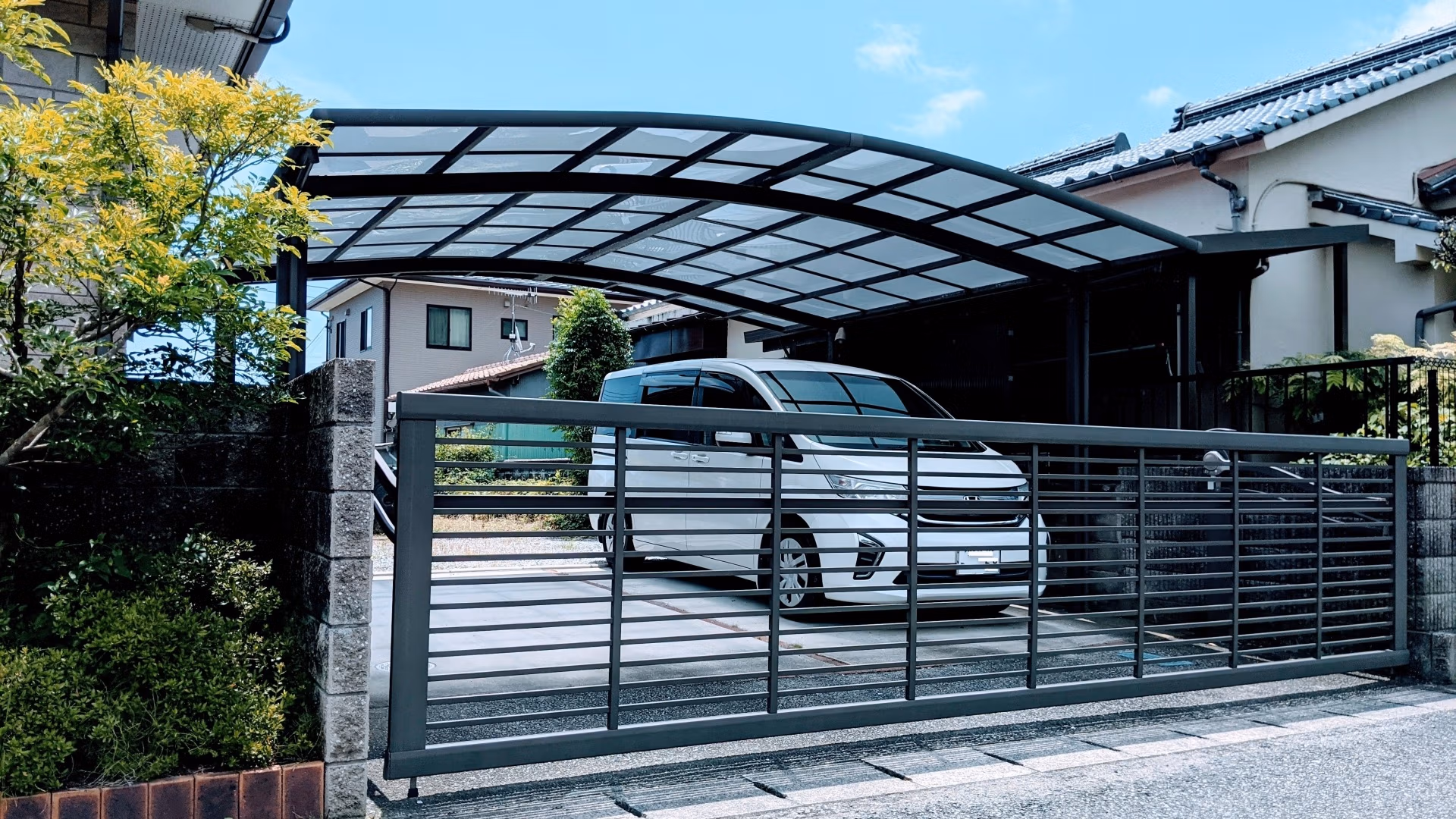 白色汽車停放於住宅車棚，選擇鍍膜可考量停車環境與用車習慣